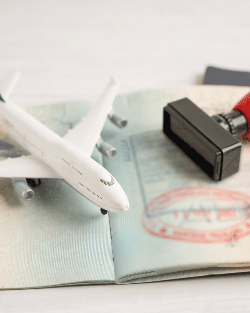 A toy airplane sitting on top of an open passport.