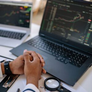 A person is holding their hands over the keyboard of his laptop.