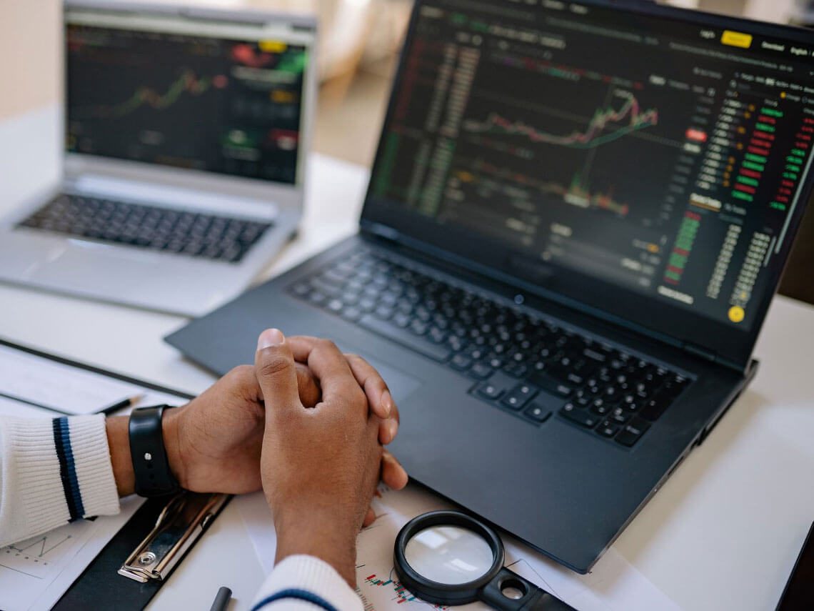 A person is holding their hands over the keyboard of his laptop.