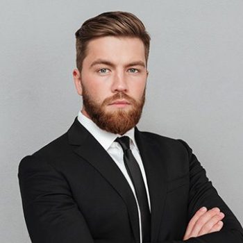 A man with beard and suit on posing for the camera.